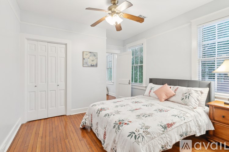 A bedroom with a large bed and a ceiling fan.