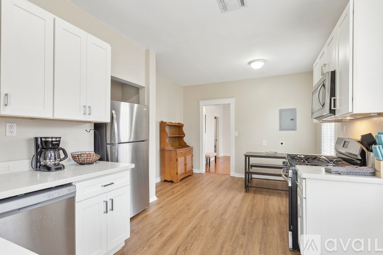 A kitchen with white cabinets and a wooden stool.