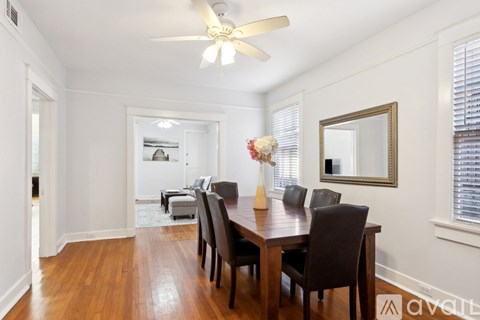 A dining room with a wooden table and chairs.