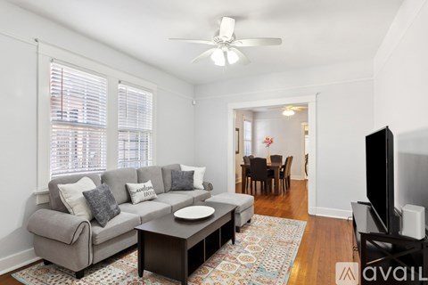 A living room with a grey couch, a coffee table, and a television.