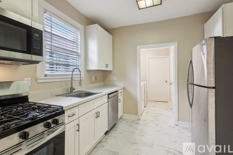 A kitchen with a black stove top oven and a white refrigerator.