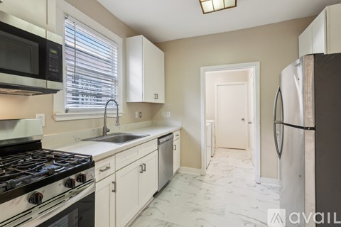 A kitchen with a black stove top oven and a white refrigerator.