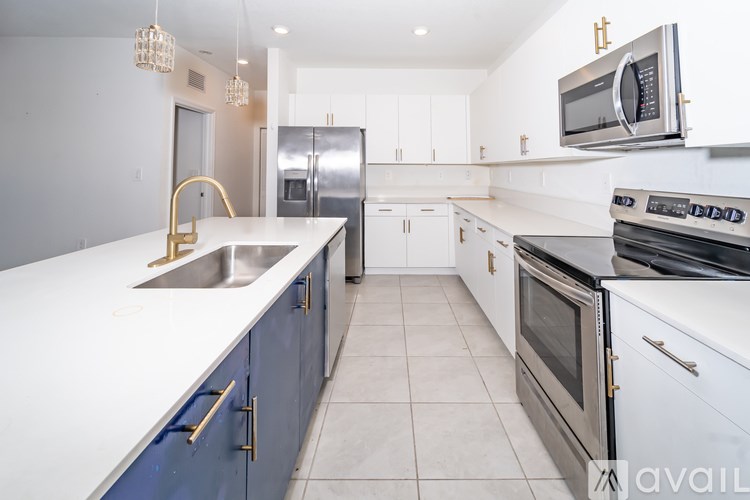 A kitchen with white countertops and blue cabinets.