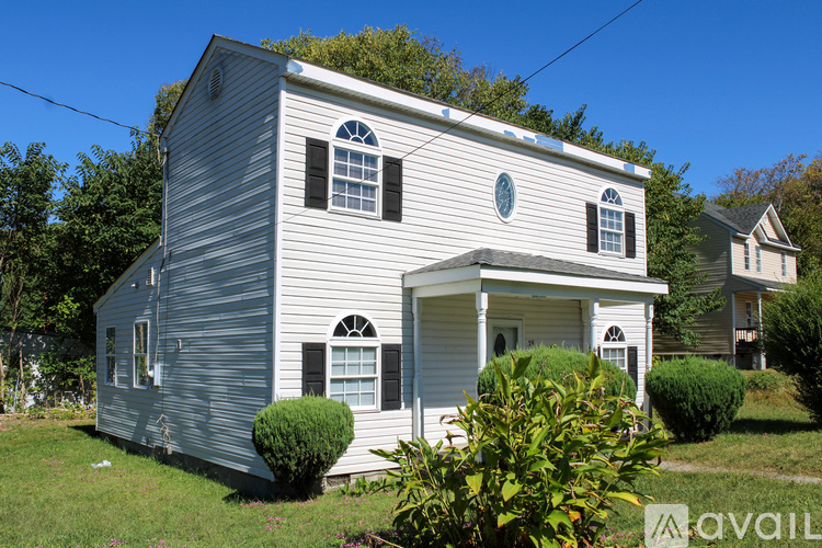 A two-story house with a grey exterior and white trim.