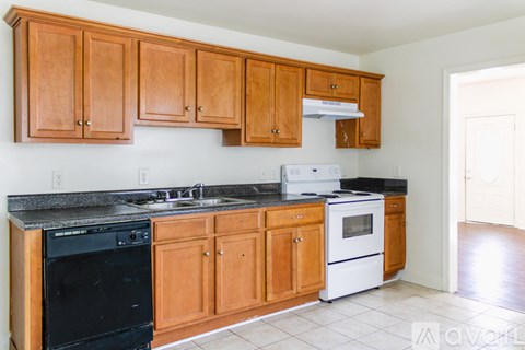 A kitchen with wooden cabinets and black appliances.
