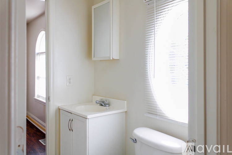 A white bathroom with a toilet, sink, and medicine cabinet.