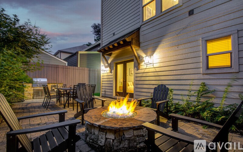 A backyard with a fire pit and chairs.