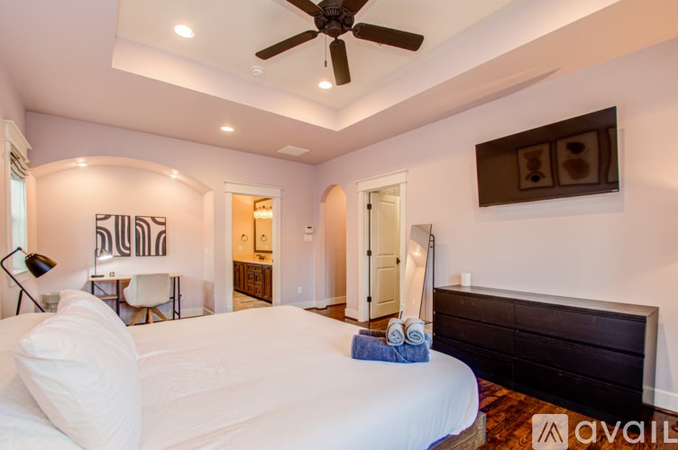 A bedroom with a large bed and a ceiling fan.