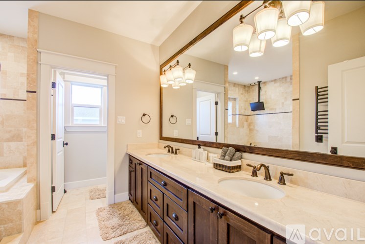 A bathroom with a marble countertop and a large mirror.