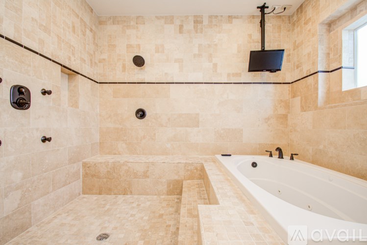 A bathroom with a tiled shower and a bathtub.