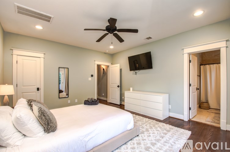 A bedroom with a large bed and a ceiling fan.