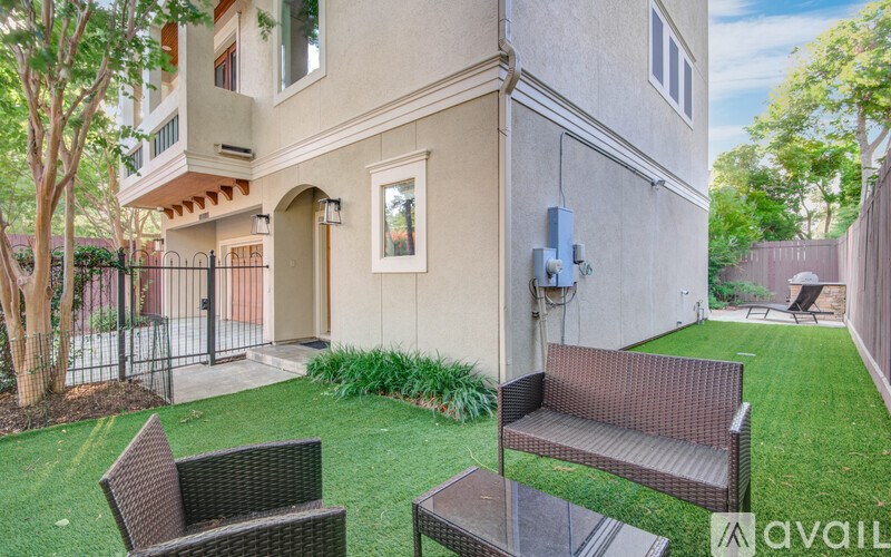 A modern house with a brown wicker chair and table in front of it.