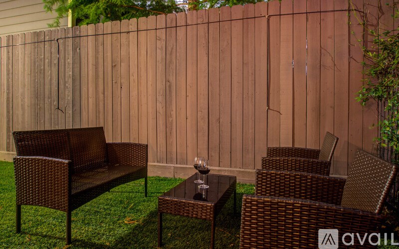 A patio set with a table and chairs is set up on a lawn.