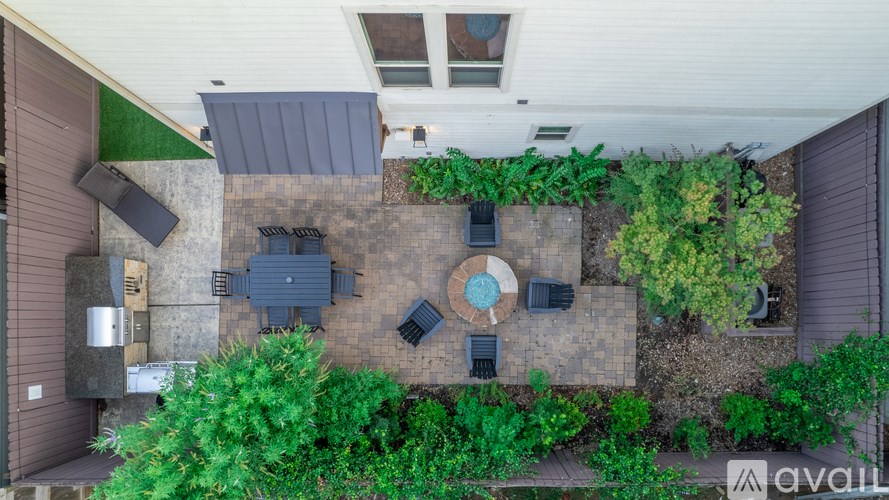 A patio with a table surrounded by green plants.