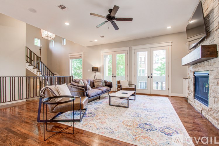 A living room with a couch, chairs, and a rug.
