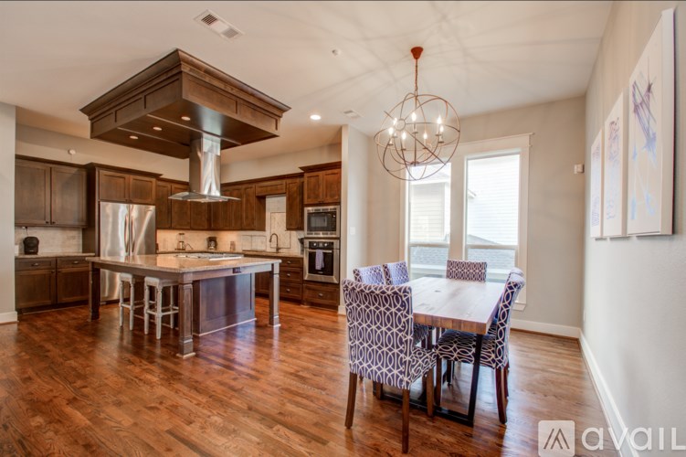 A modern kitchen with a wooden floor and a large island.