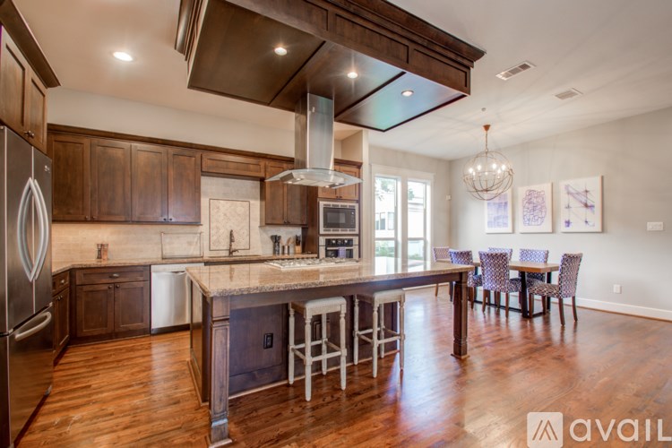 A kitchen with wooden cabinets and a large island with a bar stool.