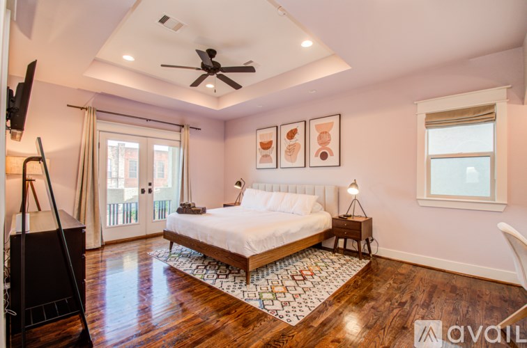 A bedroom with a bed, a ceiling fan, and a rug.