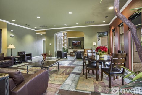 A living room with a glass table and brown leather chairs.