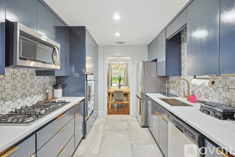 A kitchen with dark blue cabinets and a white countertop.