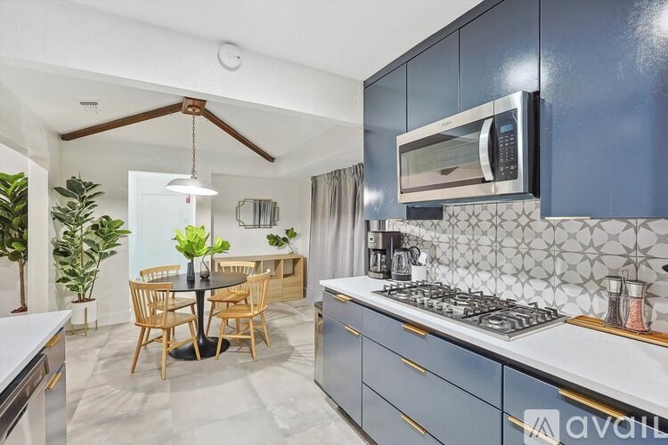 A kitchen with a dining table and chairs.