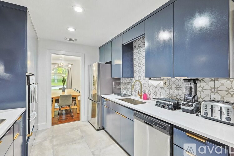 A kitchen with dark blue cabinets and white countertops.