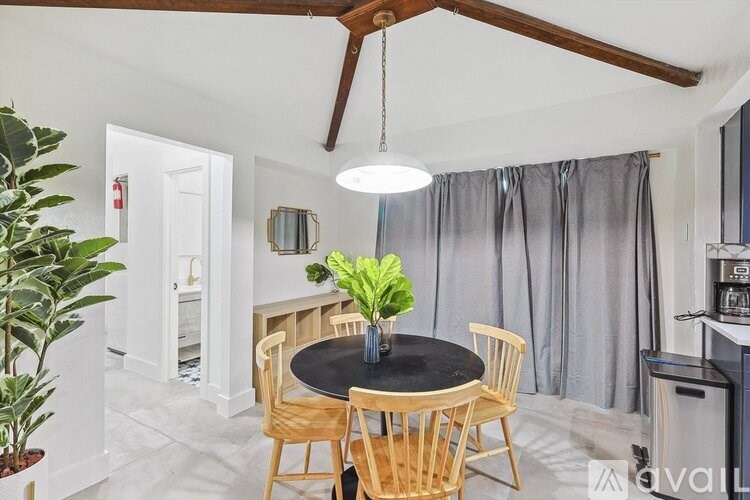 A dining room with a table and chairs.