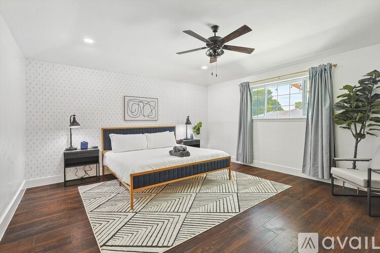 A bedroom with a bed, a ceiling fan, and a rug.