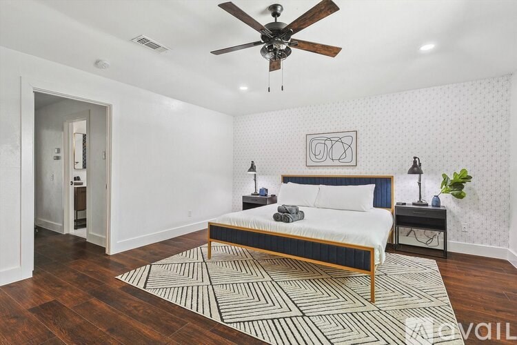 A bedroom with a bed, nightstands, and a ceiling fan.