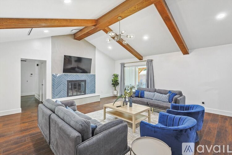 A living room with a grey couch, blue armchair, and a wooden coffee table.
