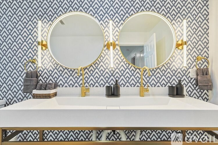 A bathroom with a white sink and two round mirrors.