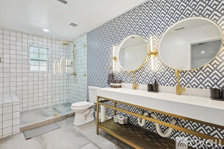 A bathroom with a white toilet and a sink with a mirror above it.