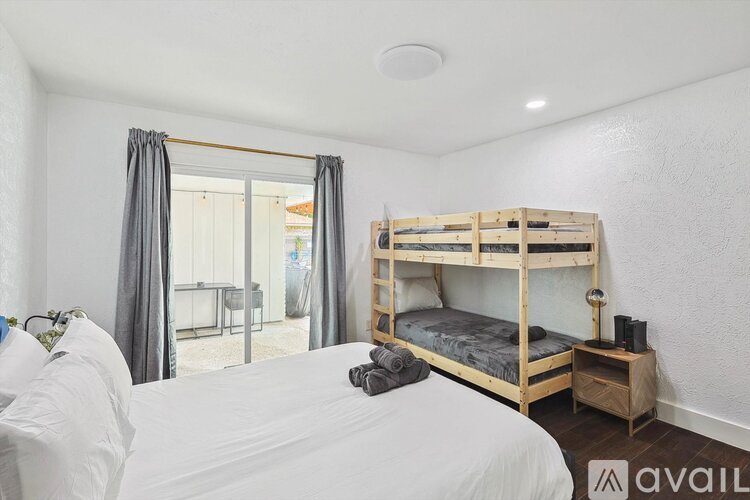 A bedroom with a bunk bed and a white bedspread.