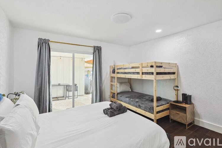 A bedroom with a bunk bed and a white bedspread.