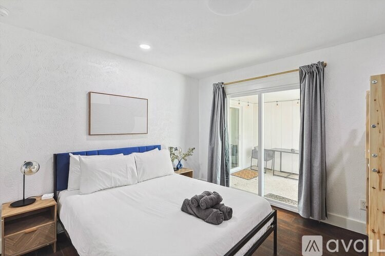 A bedroom with a large bed and a wooden nightstand.