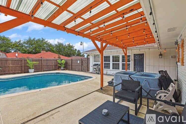 A patio with a pool and a table with chairs.