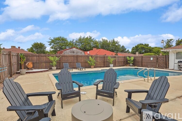 A poolside patio with a table and chairs.