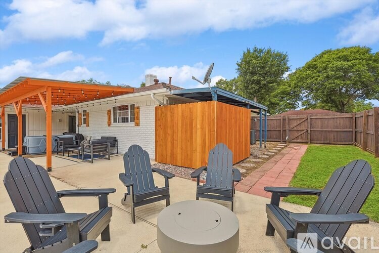A sunny backyard with a wooden fence and a patio furniture set.