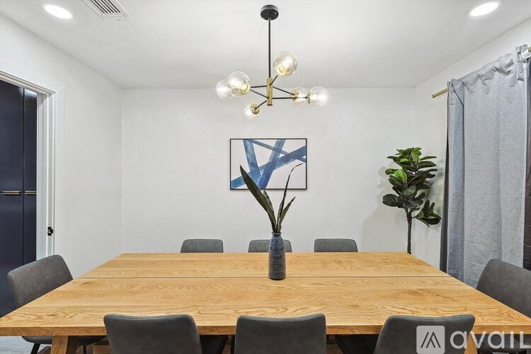 A conference room with a long table, chairs, and a blue abstract painting on the wall.