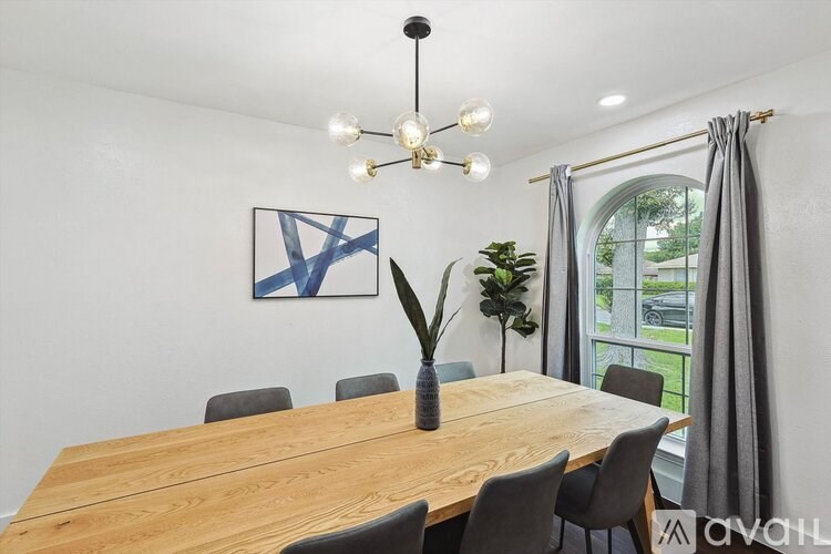 A dining room with a wooden table and chairs.
