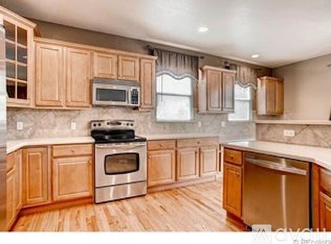 A kitchen with wooden cabinets and stainless steel appliances.
