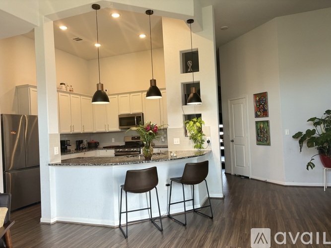 A kitchen with a bar and two chairs.