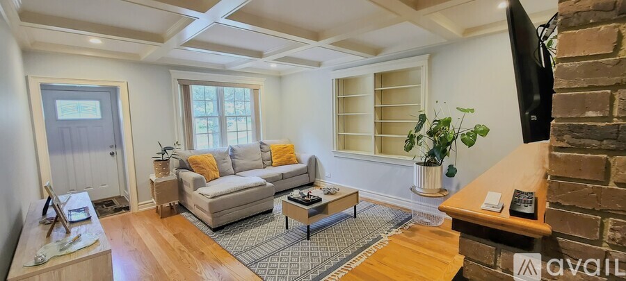 A living room with a couch, coffee table, and a flat screen TV.