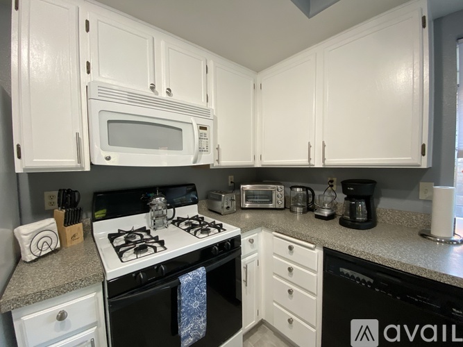 A kitchen with white cabinets and appliances.