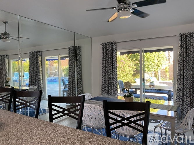 A dining room with a table and chairs.