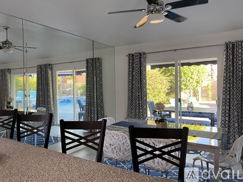A dining room with a table and chairs.
