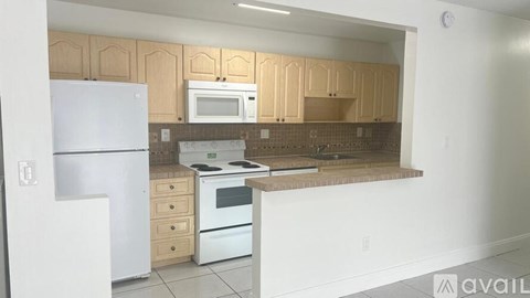 A kitchen with a white refrigerator, white microwave, and white oven.