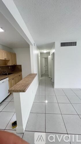 A long hallway with a bench and a door at the end.