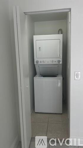 A white dryer and washer are in a small white closet.