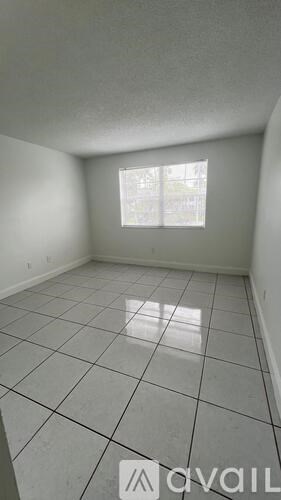 A room with a window and tiled flooring.